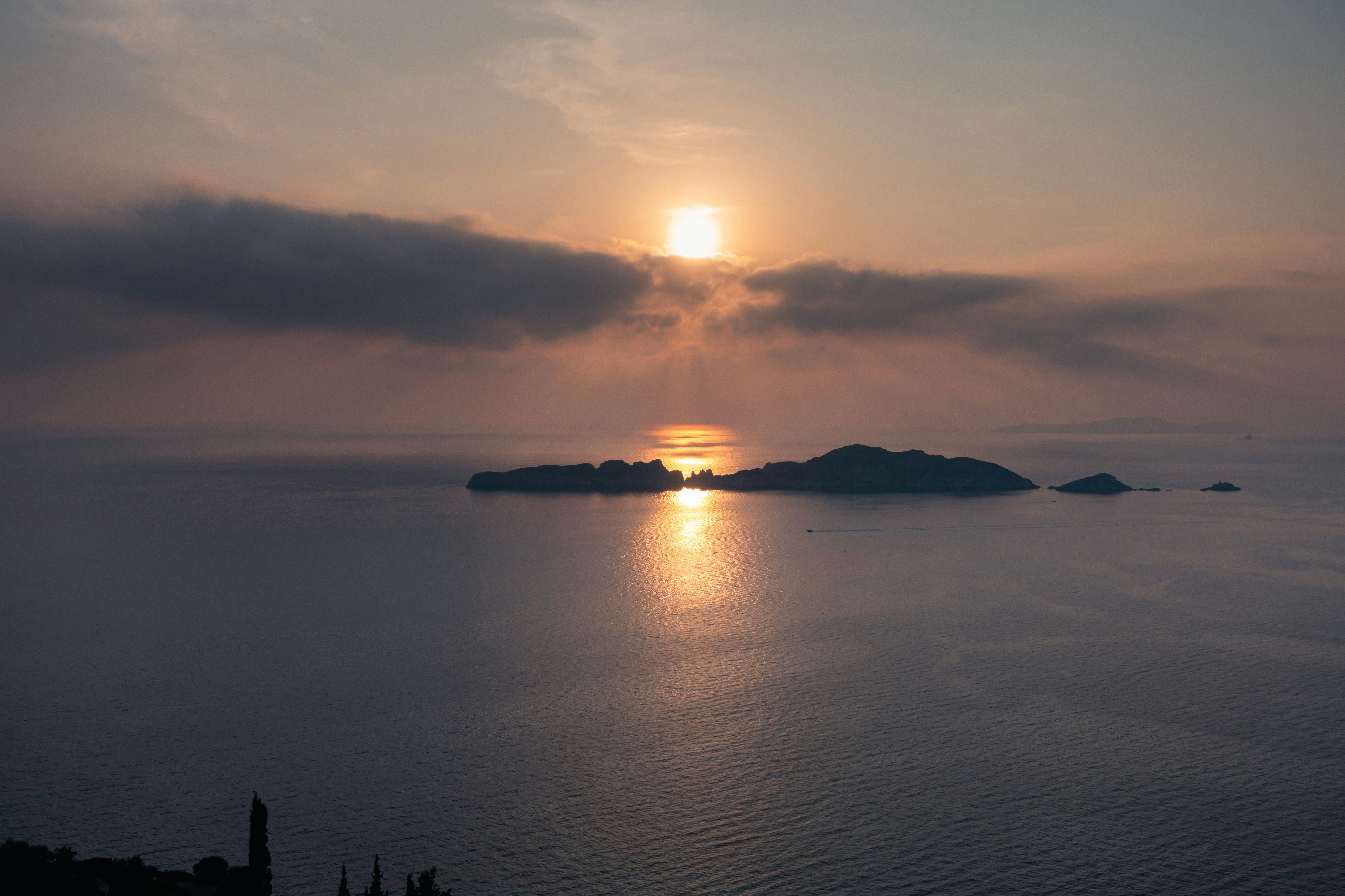 silhouette of island surrounded by sea water during dusk